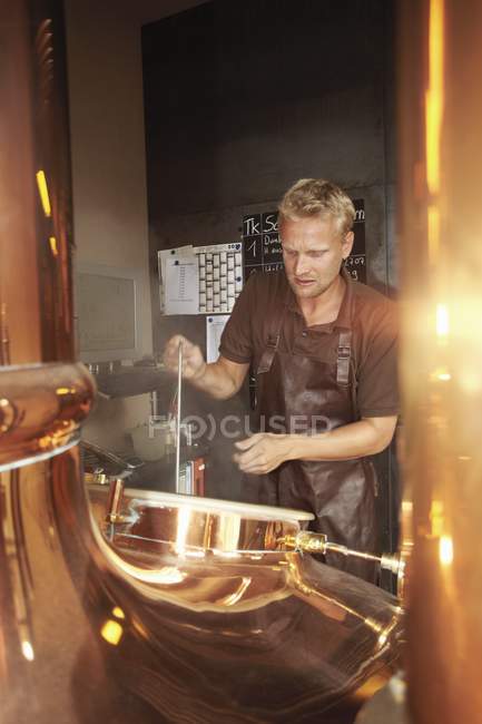 Молодой человек, работающий на пивоварне — стоковое фото