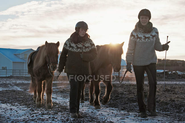 Mulheres andando com cavalos ao ar livre — Fotografia de Stock