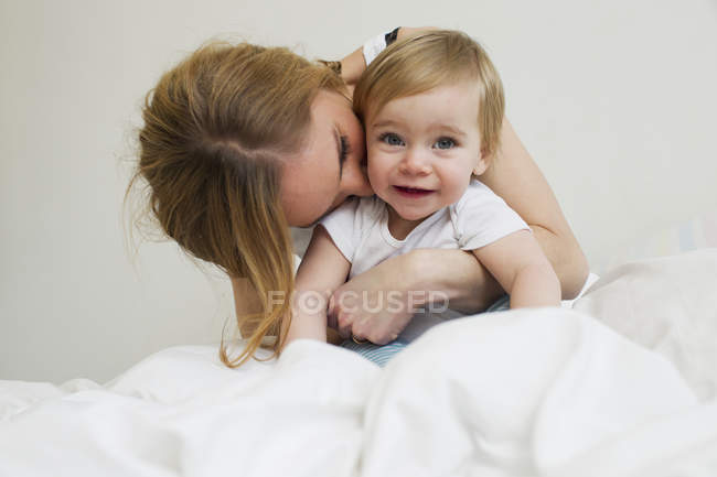 Porträt einer erwachsenen Frau, die Kleinkind-Tochter umarmt — Stockfoto