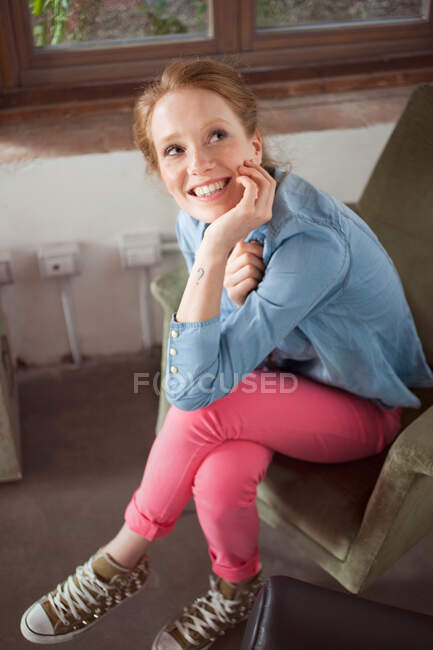 Молода жінка сидить з схрещеними ногами — стокове фото