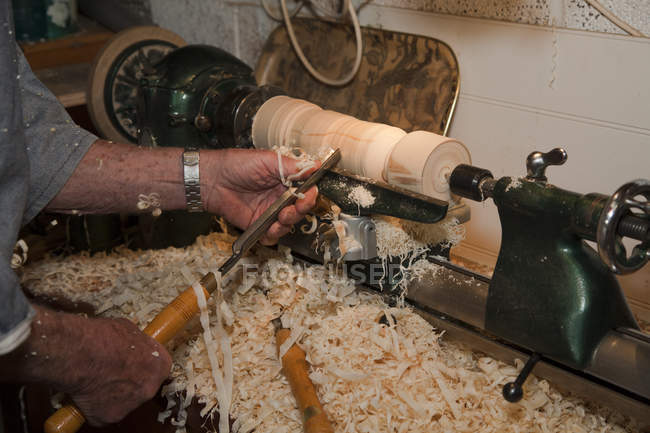 Senior man shaping piece of wood with carpentry tools, focus on hands — Stock Photo
