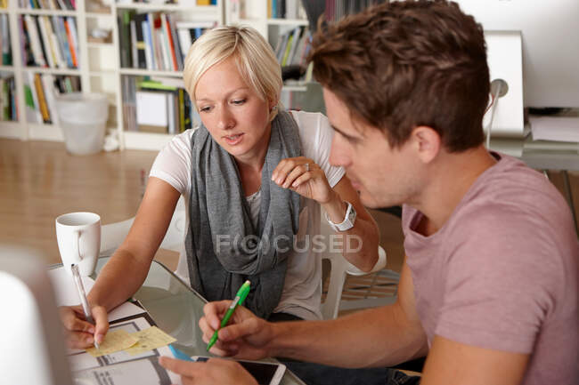 Two colleagues talking, woman making notes — Stock Photo