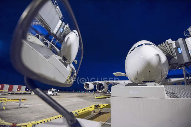Night over A380 aircraft on stand at airport, reflected in wing mirror of ground crew vehicle — Stock Photo