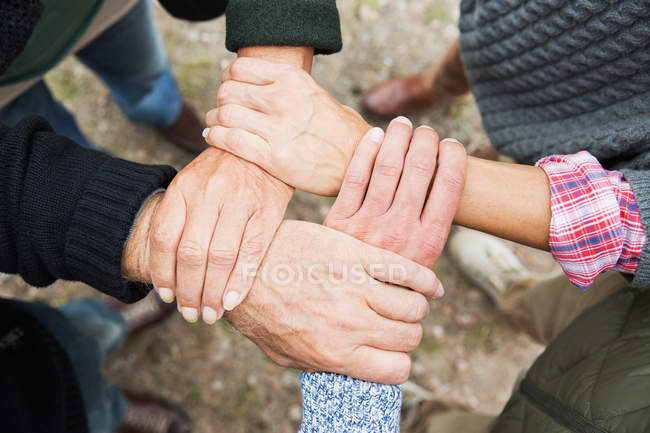 Four people touching hands, high angle — Stock Photo