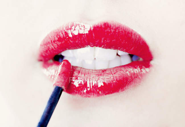 Gros plan vue partielle des lèvres féminines avec brillant à lèvres — Photo de stock