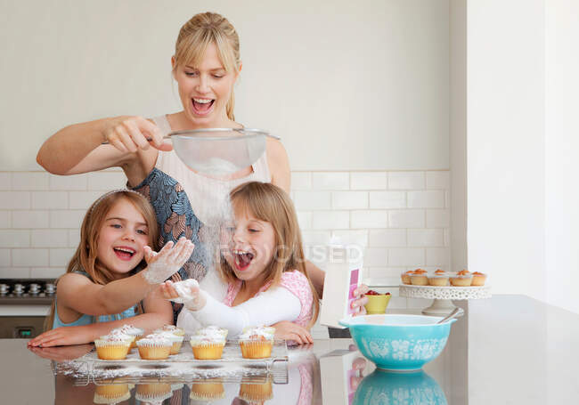 Due ragazze e una mamma che cuoce — Foto stock