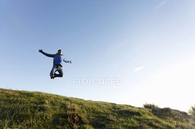 Hiker jumping on hilltop, Montseny, Barcelona, Catalunha, Espanha — Fotografia de Stock