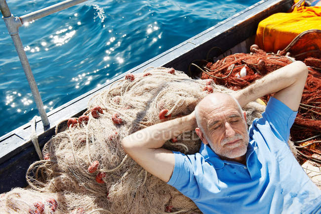 Pescatore addormentato sulle reti — Foto stock