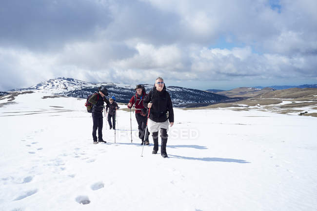 Four men hiking in snow, Bucegi Mountains, Transylvania, Romania — Stock Photo