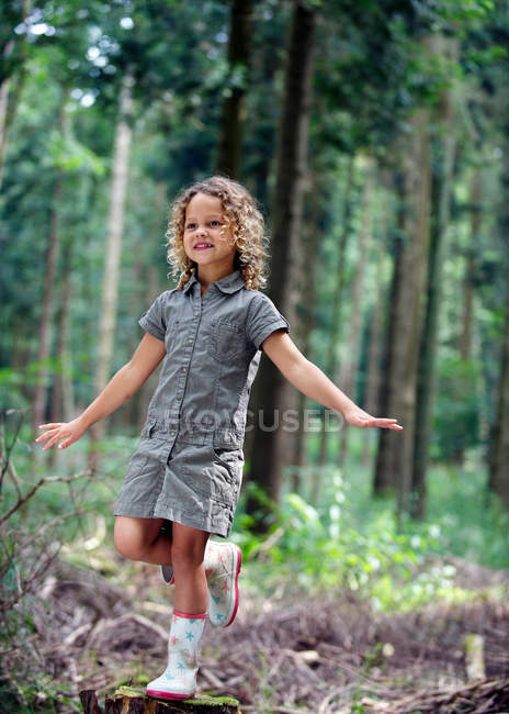 Young girl balancing in woodland — Stock Photo