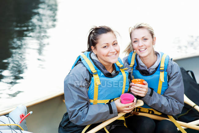 Women having coffee in canoe — Stock Photo