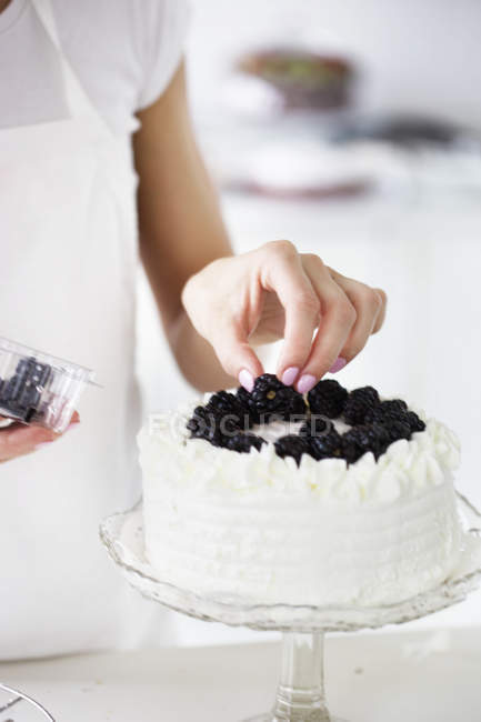 Frau dekoriert Kuchen — Stockfoto