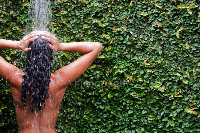 Dos d'une femme prenant une douche — Photo de stock