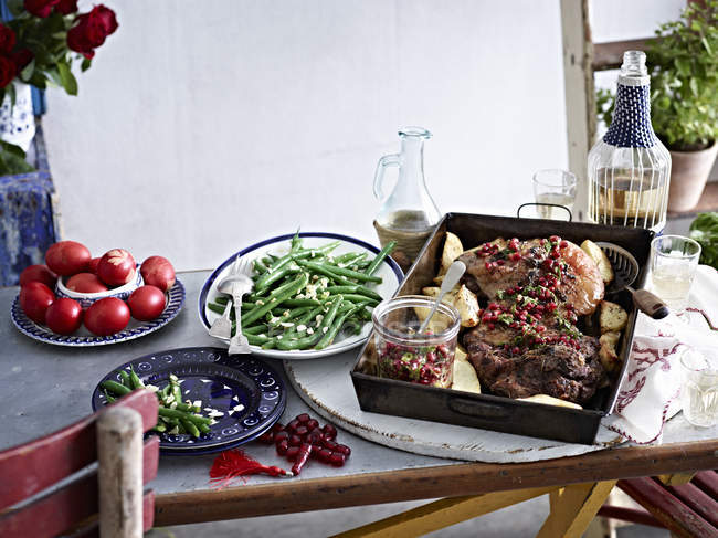 Still life of roasted lamb with pomegranate seeds and vegetables — Stock Photo