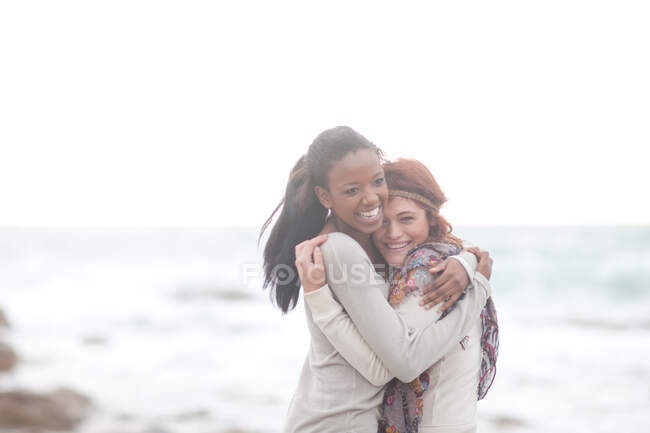 Friends hugging on beach — Stock Photo