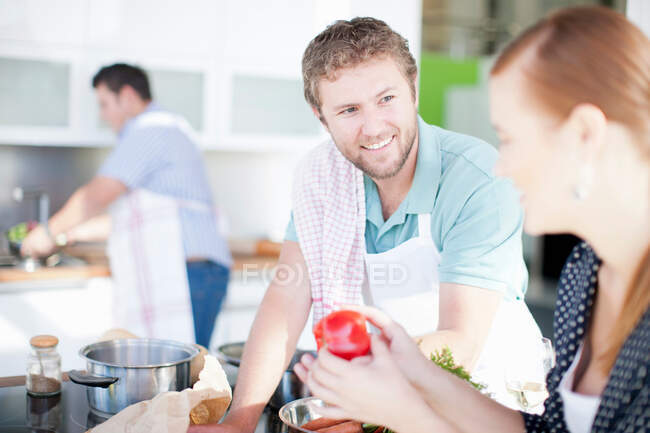 Friends cooking together in kitchen — Stock Photo