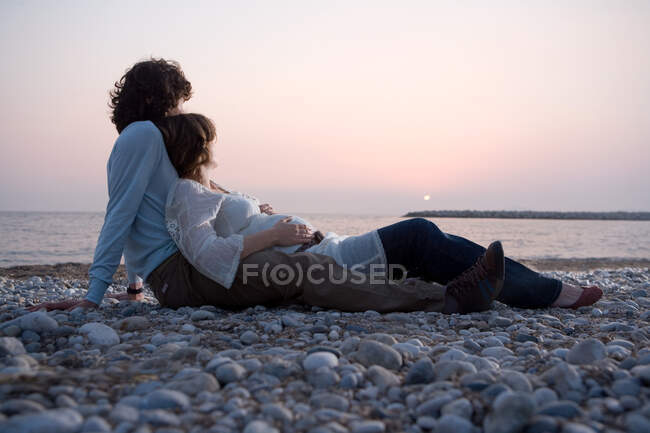 Молодая пара лежит на пляже — стоковое фото