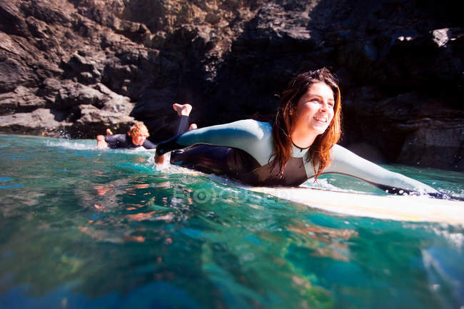 Casal deitado em pranchas de surf na água — Fotografia de Stock