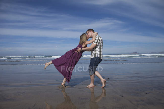 Portrait of couple kissing on sea shore — Stock Photo
