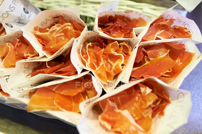 Cured ham in paper bundles — Stock Photo