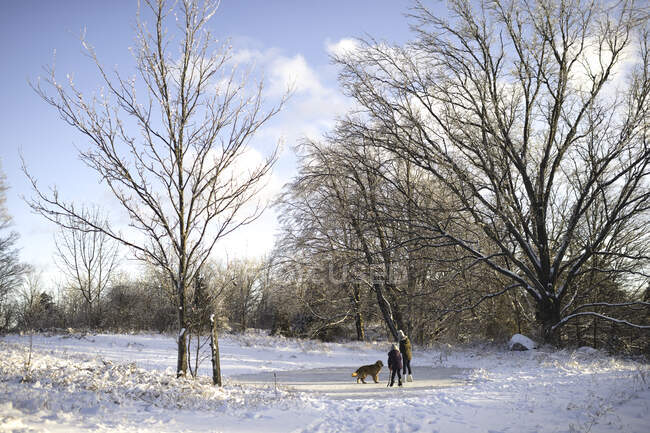 Deux jeunes filles avec chien dans un paysage enneigé — Photo de stock