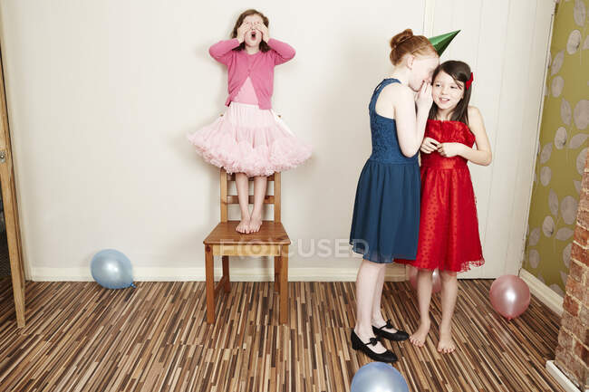 Three girls playing hide and seek at birthday party — Stock Photo