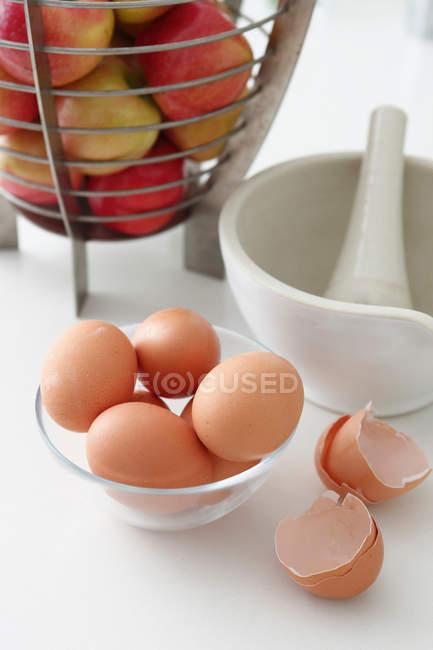 Bowls of eggs and apples — Stock Photo