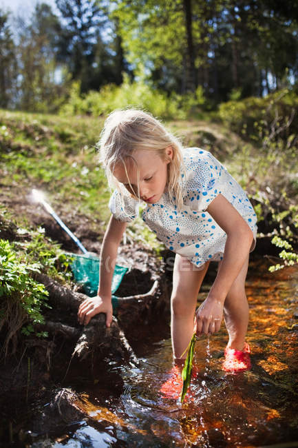 Petite fille jouer dans ruisseau — Photo de stock