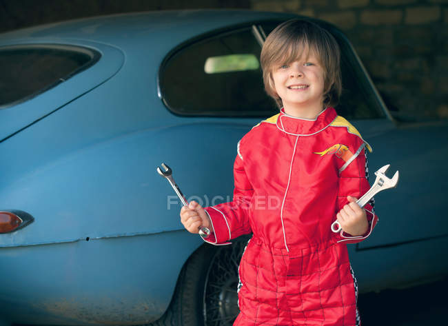 Niño con traje de conductor de coche de carrera - foto de stock