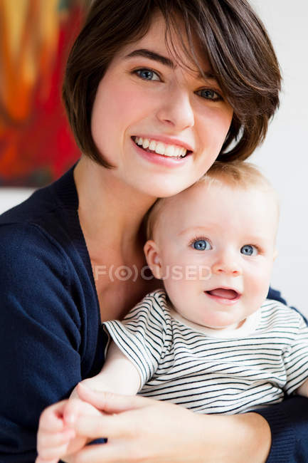 Sorrindo mãe segurando bebê — Fotografia de Stock