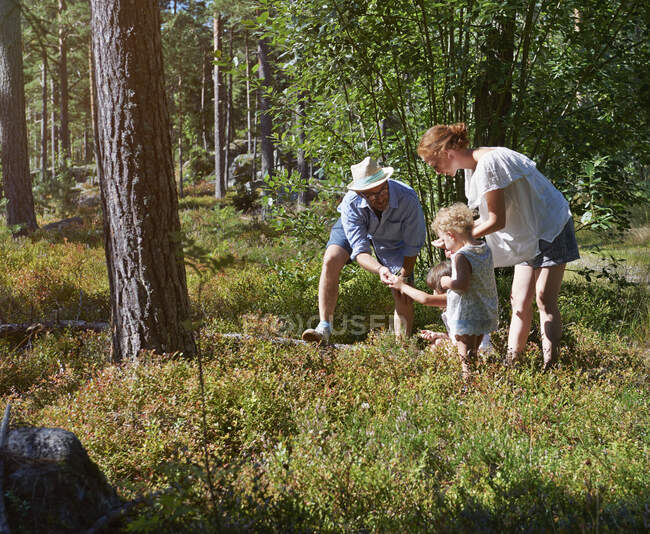 Pais e filhas explorando na floresta — Fotografia de Stock