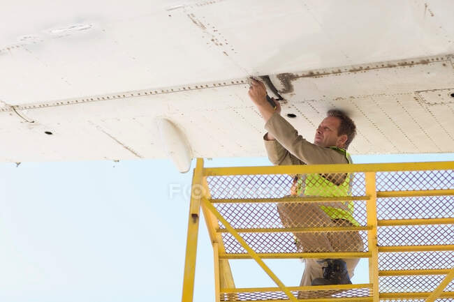 Aircraft worker repairing airplane — Stock Photo