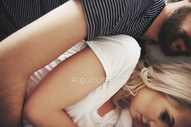 Paar liegt im Bett, umarmt, Mittelteil, Nahaufnahme — Stockfoto