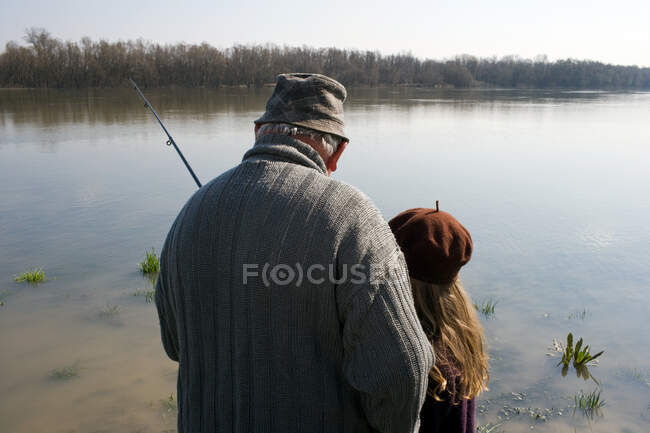 Дедушка и внучка рыбачат — стоковое фото