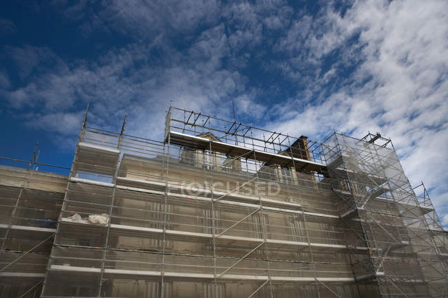 Unfinished house in construction under blue cloudy sky — Stock Photo