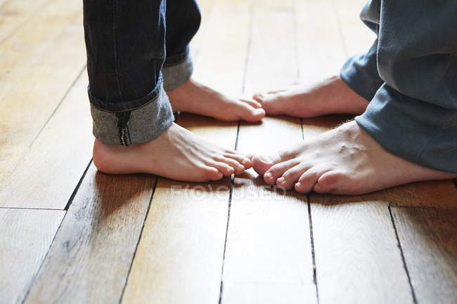 Father And Son Feet On Wooden Floor Two People Close Up Stock Father And Son Feet On Wooden Floor Stock Photo