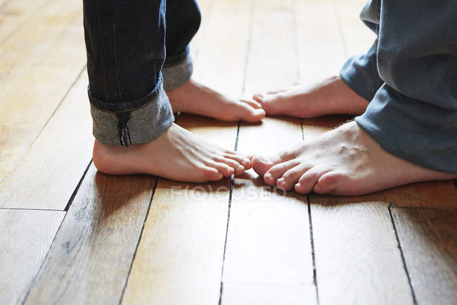 Father and son feet on wooden floor — Stock Photo