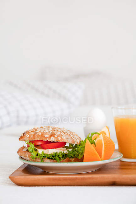 Bandeja de sándwich de desayuno y vaso de jugo - foto de stock