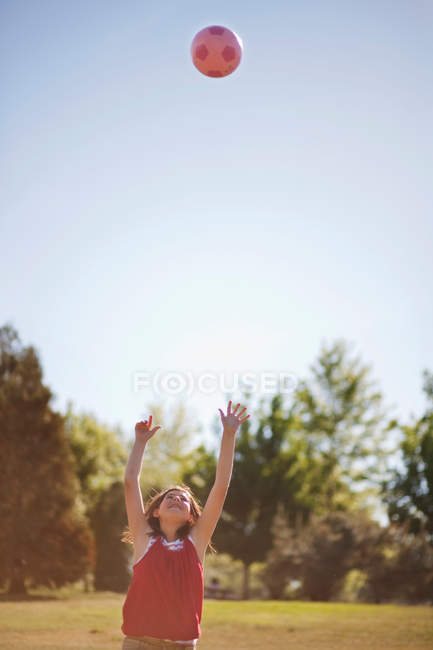 Girl playing with soccer ball in field — Stock Photo