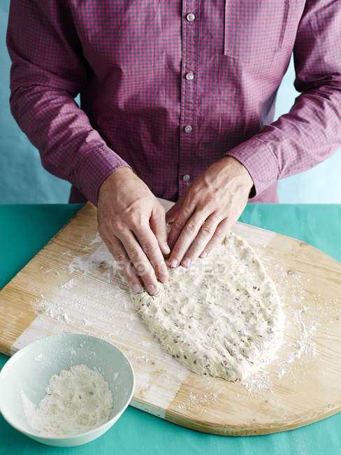 Man preparing unkneaded bread recipe step 2, shaping bread dough — Stock Photo