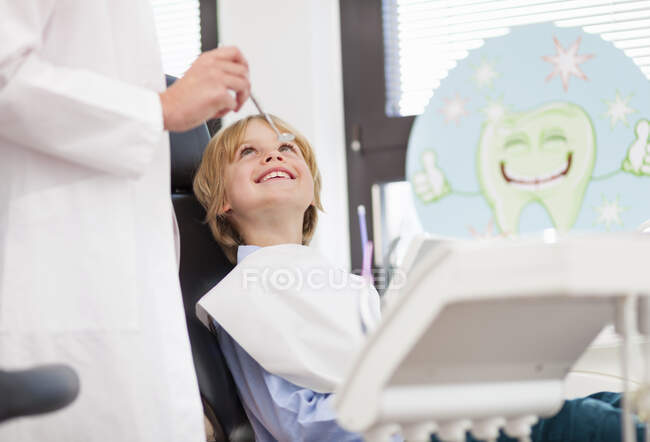 Мальчик в кресле стоматолога проверяет — стоковое фото
