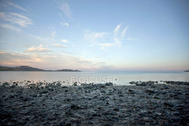 Stilles Wasser am felsigen Strand — Stockfoto