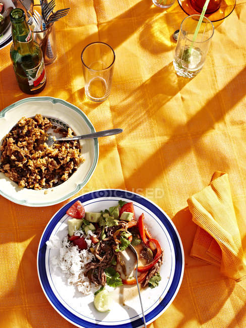 Верхний вид национальных блюд Кубы Ropa Vieja на желтый стол — стоковое фото
