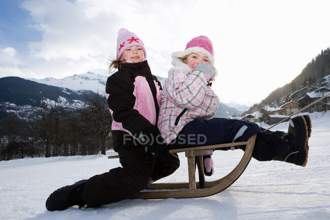 Девушки буксируются на санях в снегу — стоковое фото