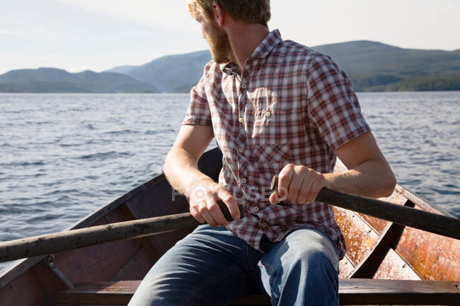 Man rowing boat on lake — Stock Photo