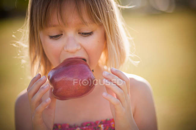 Ragazza mangiare mela all'aperto — Foto stock