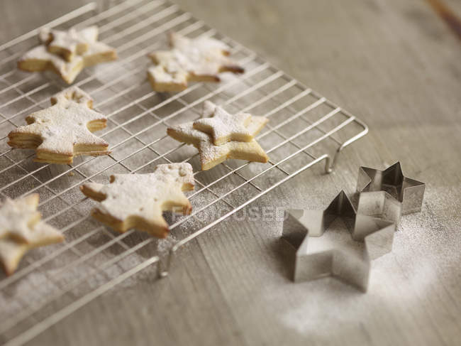 Close up of freshly baked christmas biscuits on cooling rack — Stock Photo