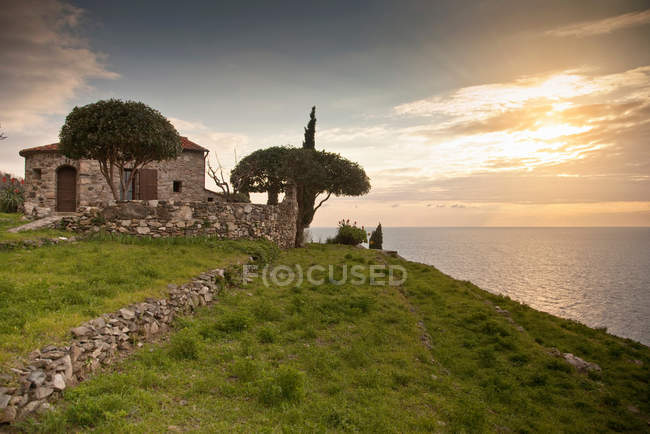 Stone house overlooking coastline — Stock Photo