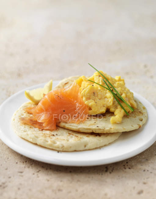 Копчений лосось і яєчня на бліні з сирним гарніром — стокове фото