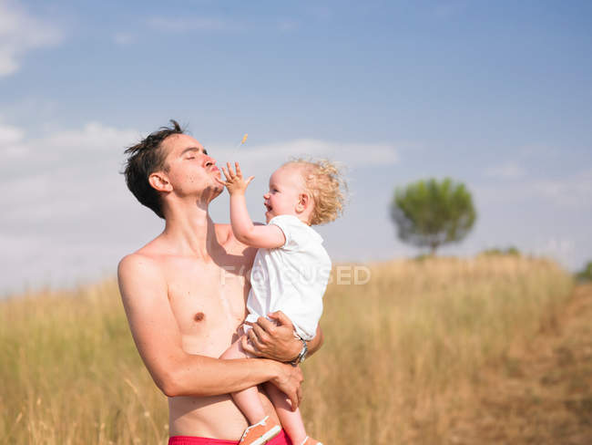 Homme portant son fils à l'extérieur — Photo de stock